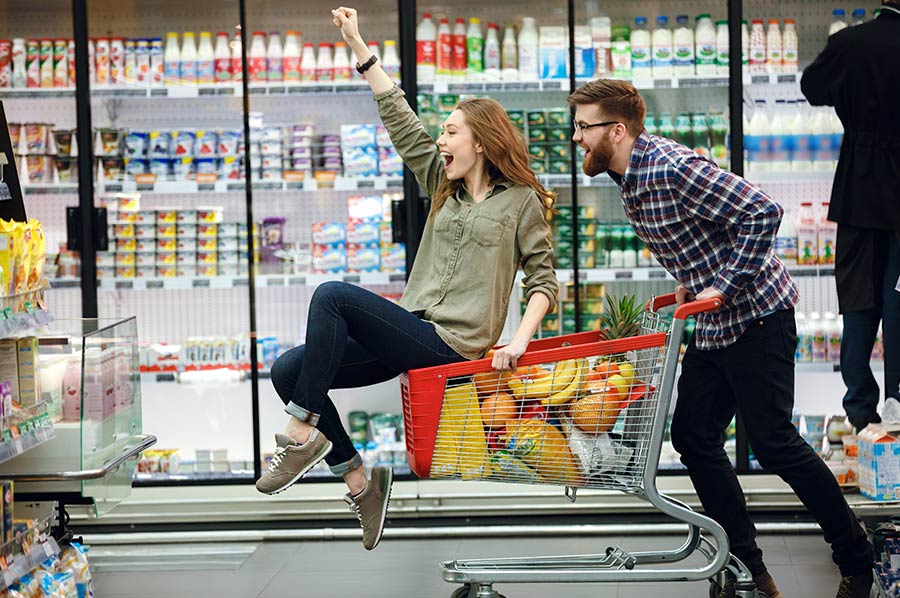 Pareja divirtiéndose en el supermercado, para evitar la rutina